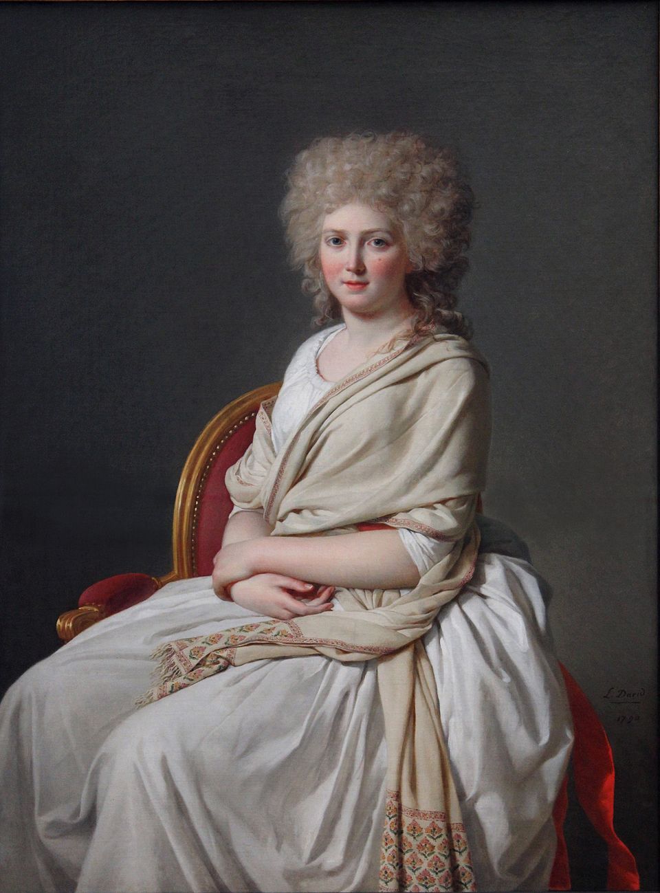 Portrait of a woman in a white dress with a shawl, sitting in a chair against a dark background