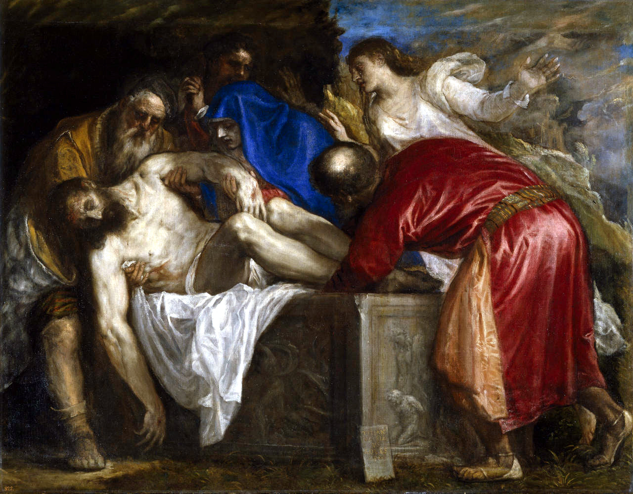 Artistic depiction of a religious scene with figures around a central figure on a table. The Burial of Christ by Titian | Museo del Prado Madrid
