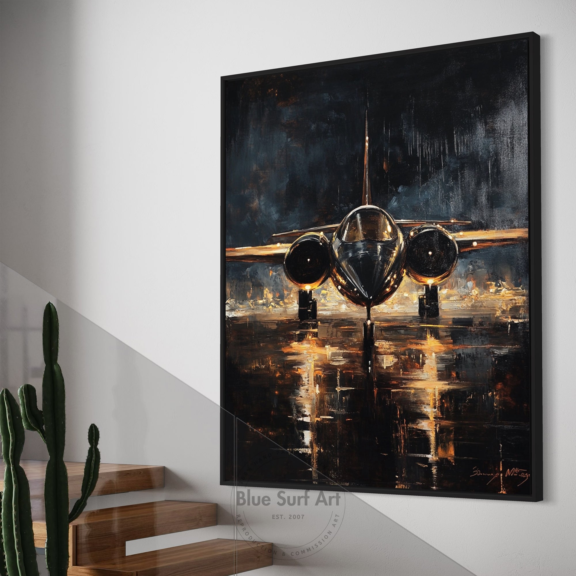 Framed painting of an airplane on a wall with a plant and staircase in the foreground.