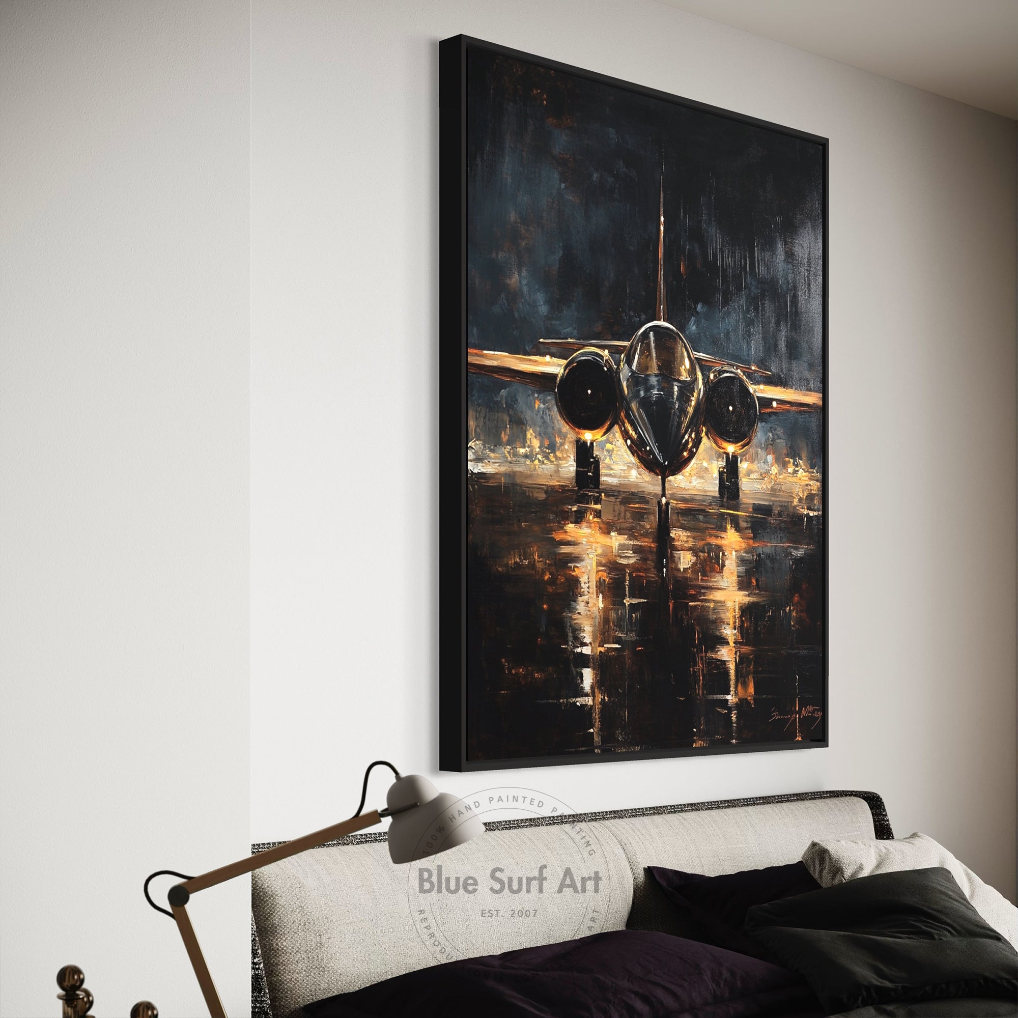 Framed painting of an airplane on a wall above a bed.