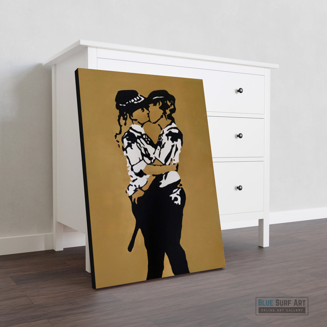 Canvas print of a stylized black and white illustration against a gold background, leaning against a white cabinet.  Iconic Kissing Coppers Reproduction Hand-Painted Oil on Canvas