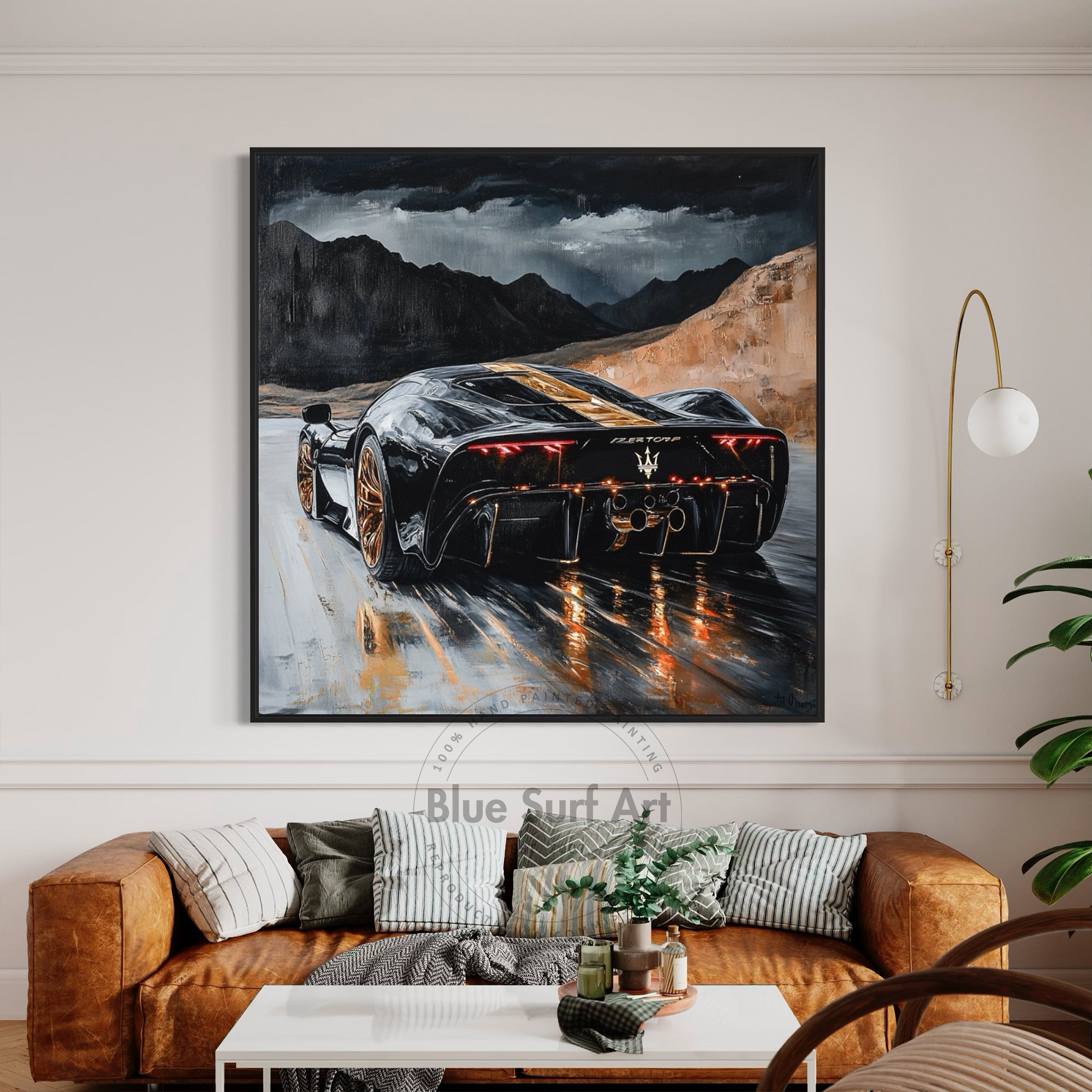 Framed artwork of a sports car on a wall above a sofa in a living room.
